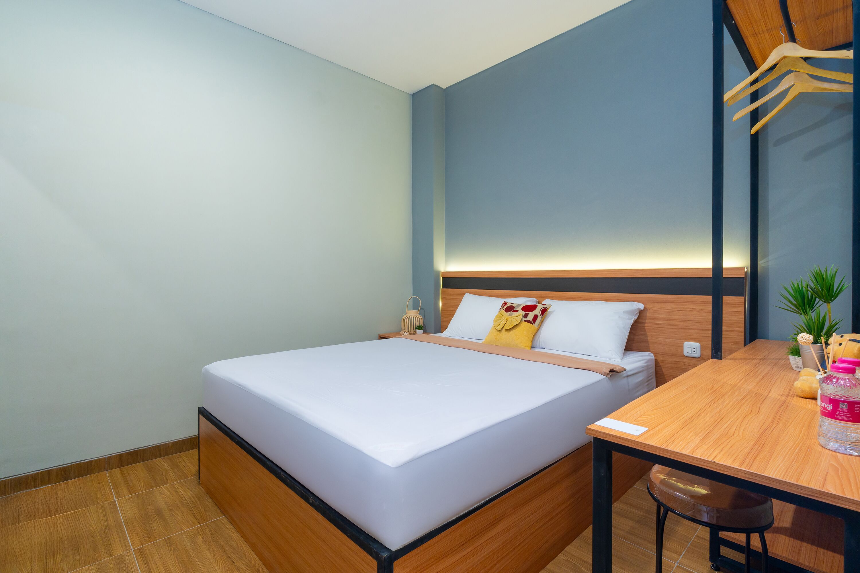 A neatly arranged hotel room with a bed, a wooden table, and a small seating area.
