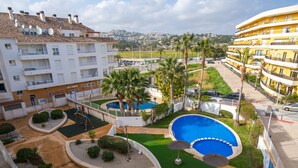 A residential area with a swimming pool, palm trees, and a view of a hilly landscape. - Cala Mora by Interhome (Moraira)