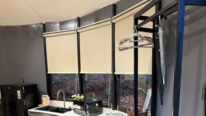 A compact kitchen with a curved countertop, a sink, and a black refrigerator. - Dong Homestay  (Xuan Huong - Da Lat)