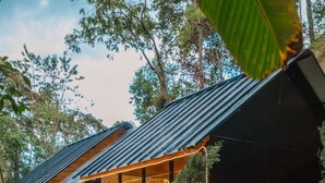 A modern wooden cabin with a large glass-enclosed porch, a wooden hot tub, and a metal roof. - LOUVREFER (Mae Taeng)