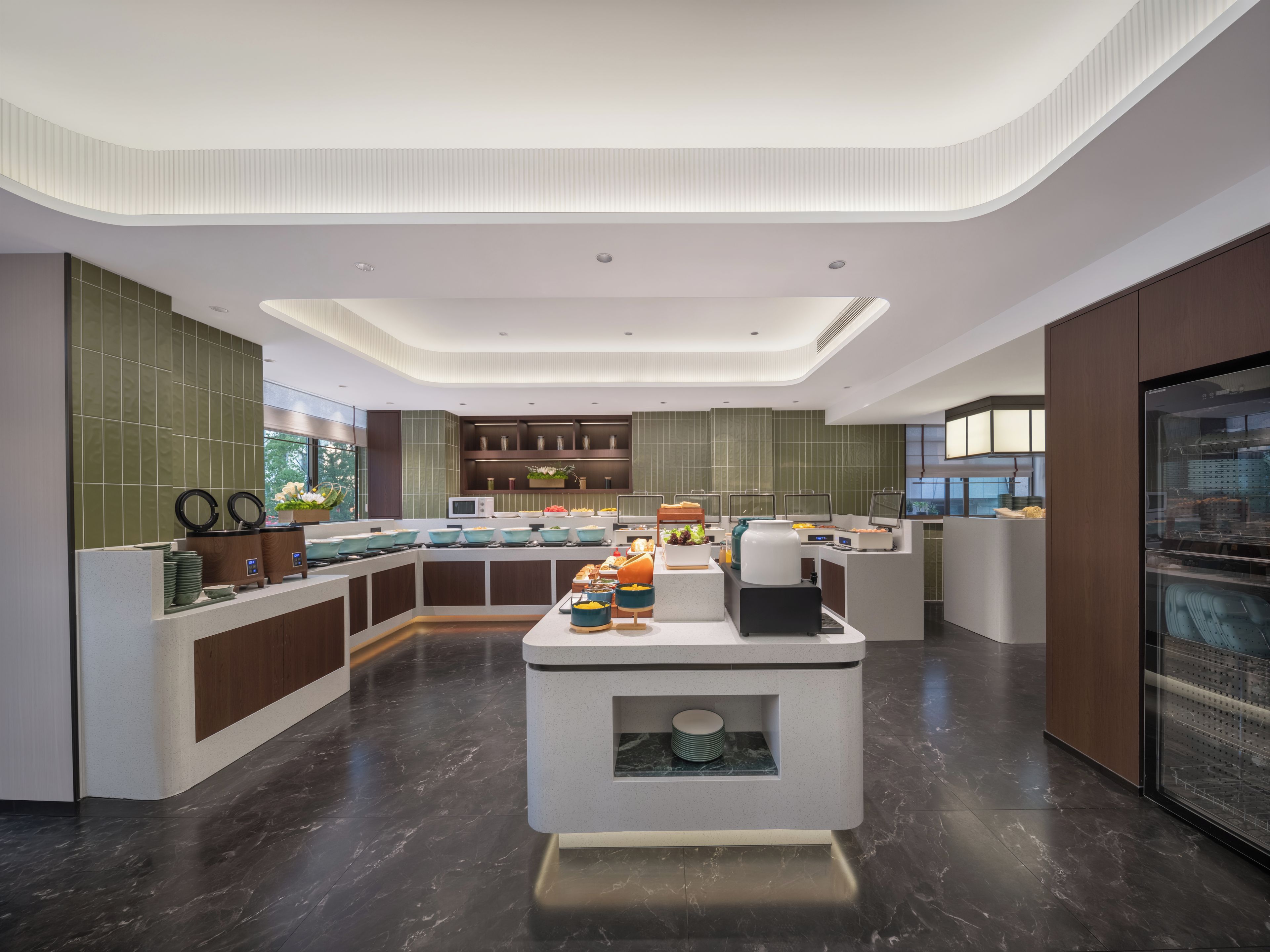 Un espace moderne dédié au petit-déjeuner, doté d’un buffet central, d’un four à micro-ondes et d’un réfrigérateur.