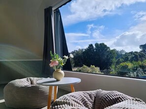Et værelse med et rundt bord, en polstret bænk og en vase med blomster.
