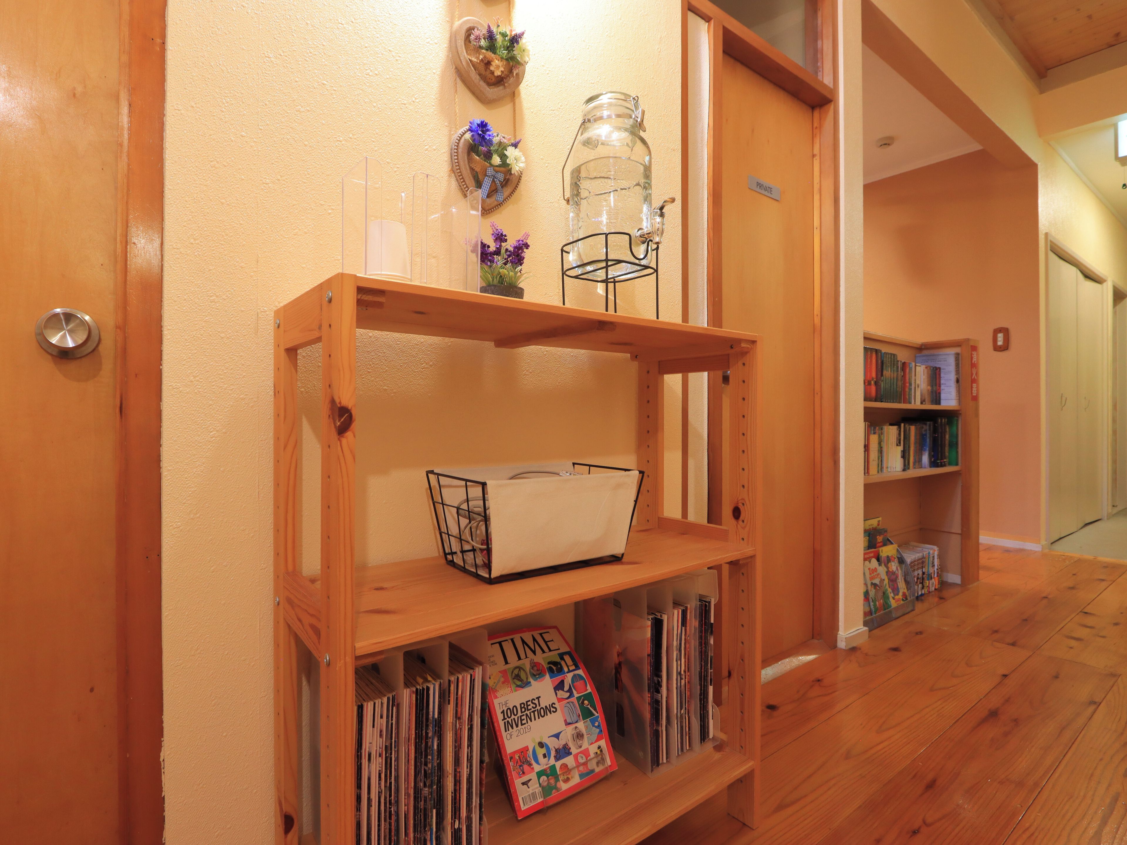 A wooden bookshelf with magazines and a TIME magazine on the lower shelf.