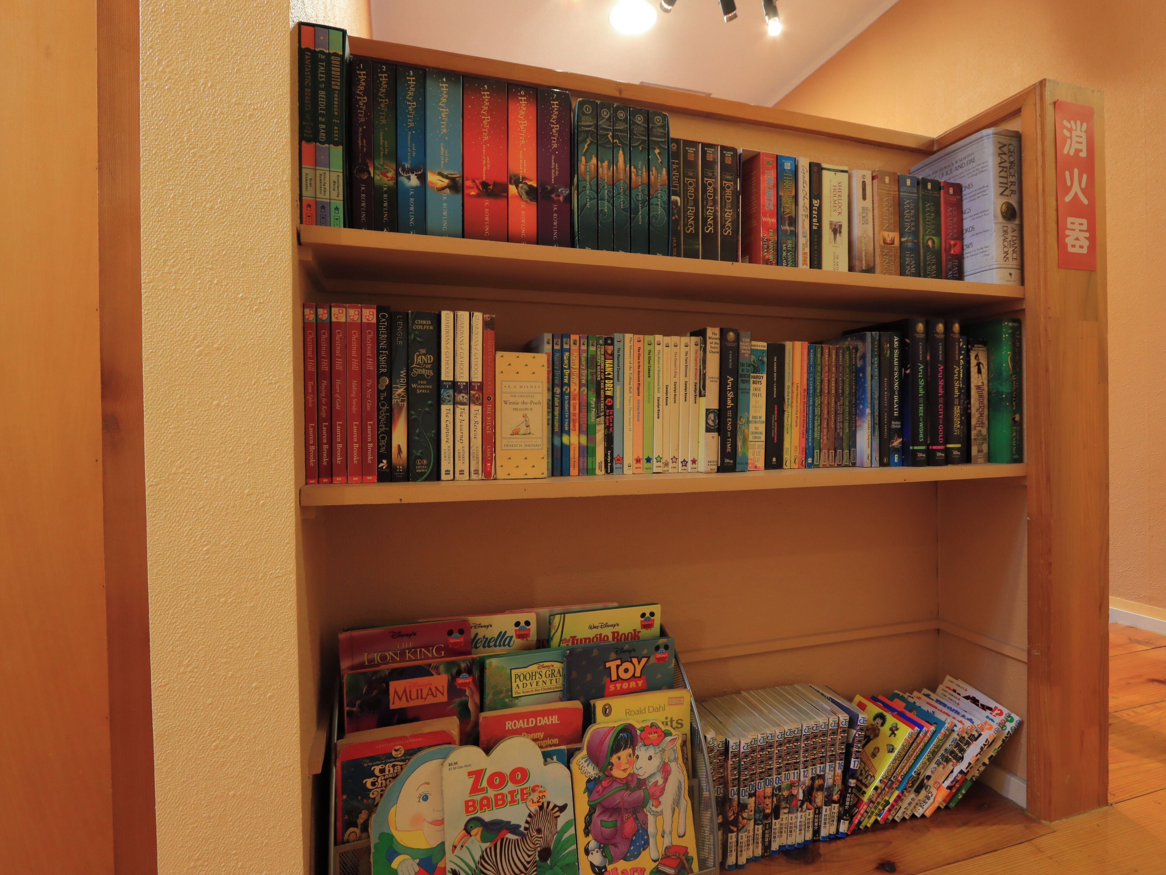 Una estantería con varios libros y juguetes infantiles.