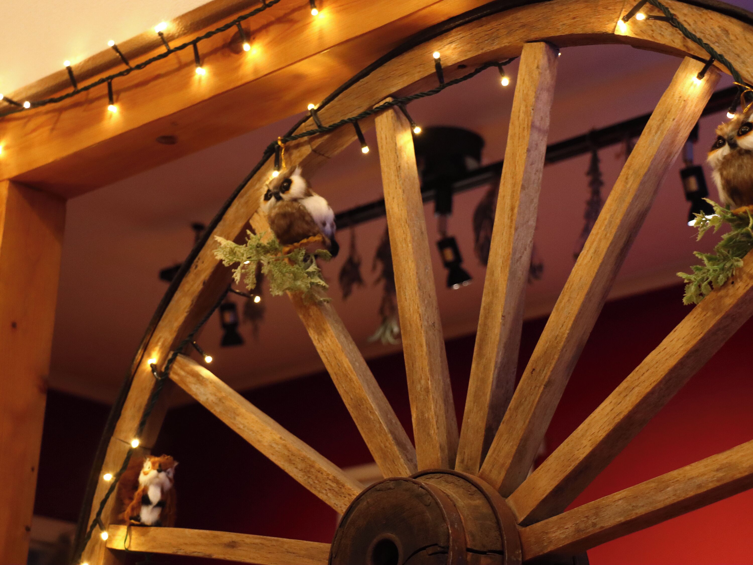 A wooden wheel with lights and hanging ornaments.
