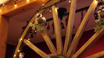 A wooden wheel with lights and hanging ornaments.