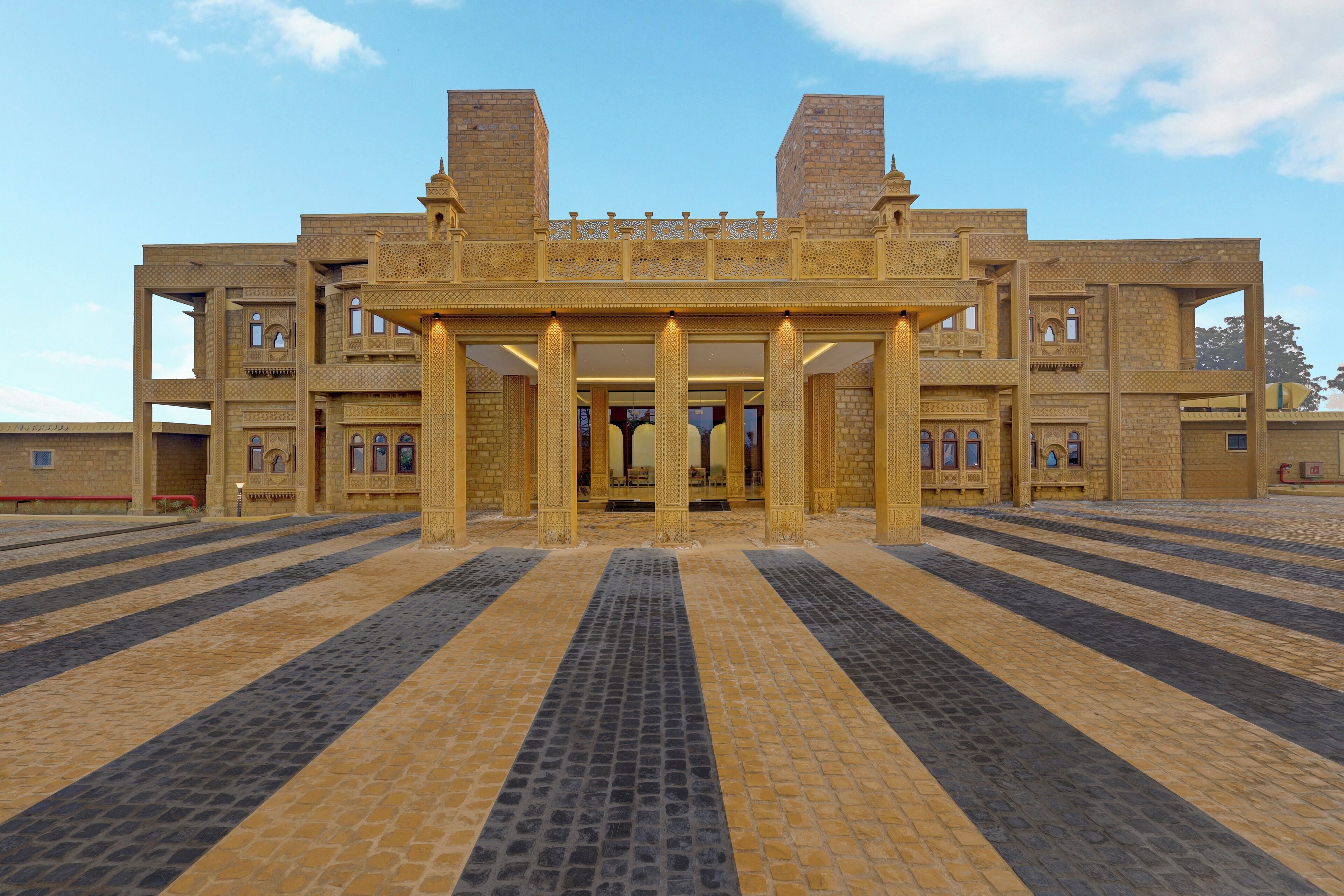 A large building with a central entrance, multiple balconies, and a tiled floor.