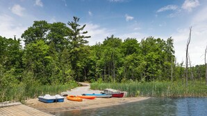 A dock with boats and a forested area.