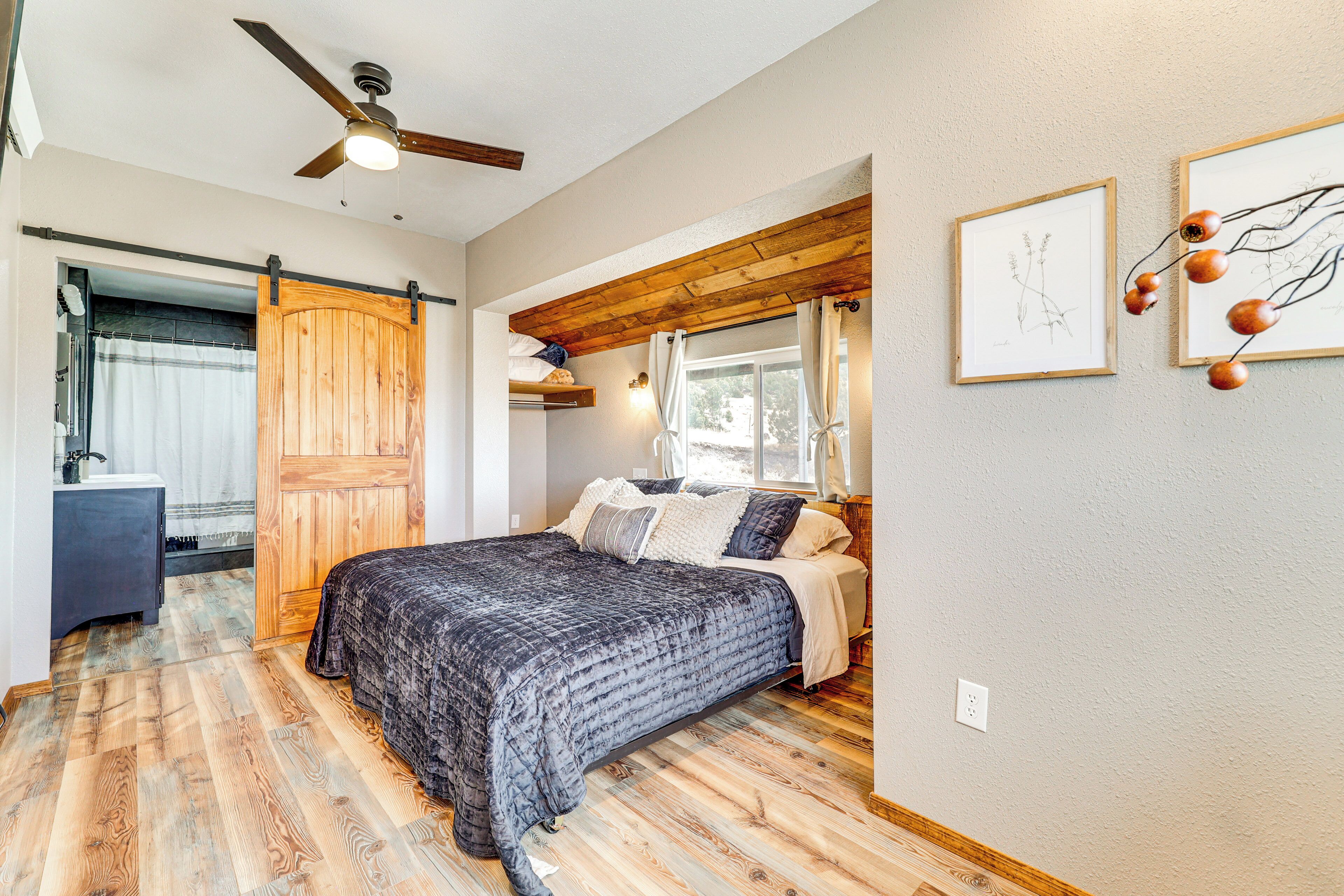 Un dormitorio con cama, techo de madera y ventilador de techo.