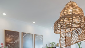 Een moderne keuken met een centraal eiland, hanglampen en kunst aan de muur.