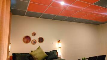 Una habitación de hotel con cama, almohadas, mesita de noche, lámpara y decoración en la pared.