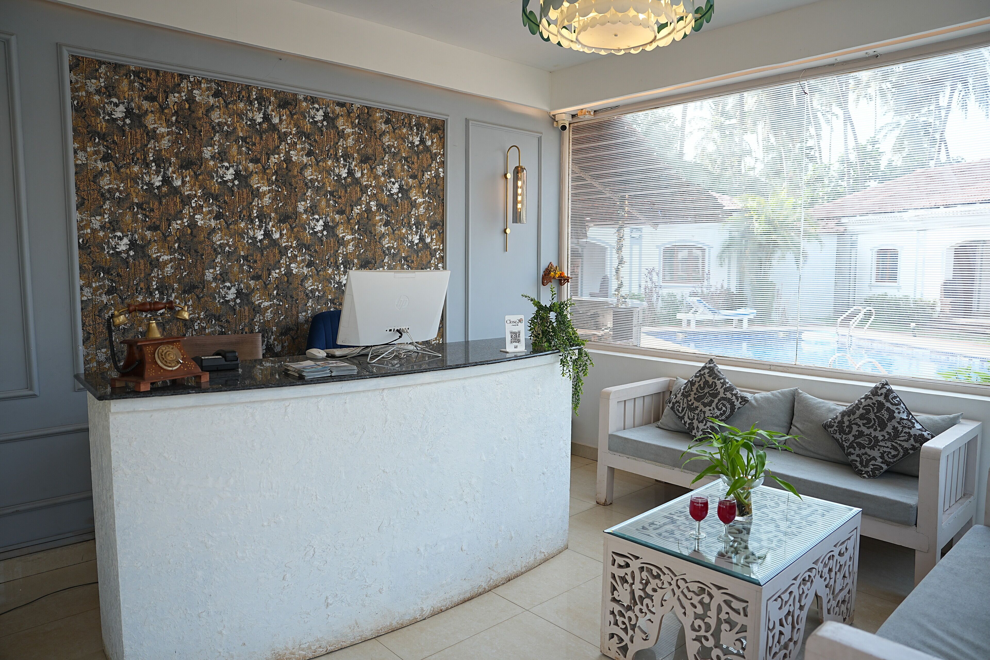 A modern kitchen with a white countertop, a decorative wall, and a seating area with a sofa and a table.