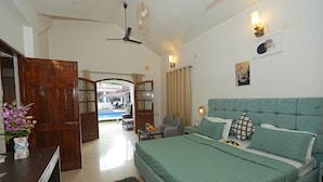 Un dormitorio con una cama grande, un escritorio y una silla. Hay una puerta que da a un área exterior.