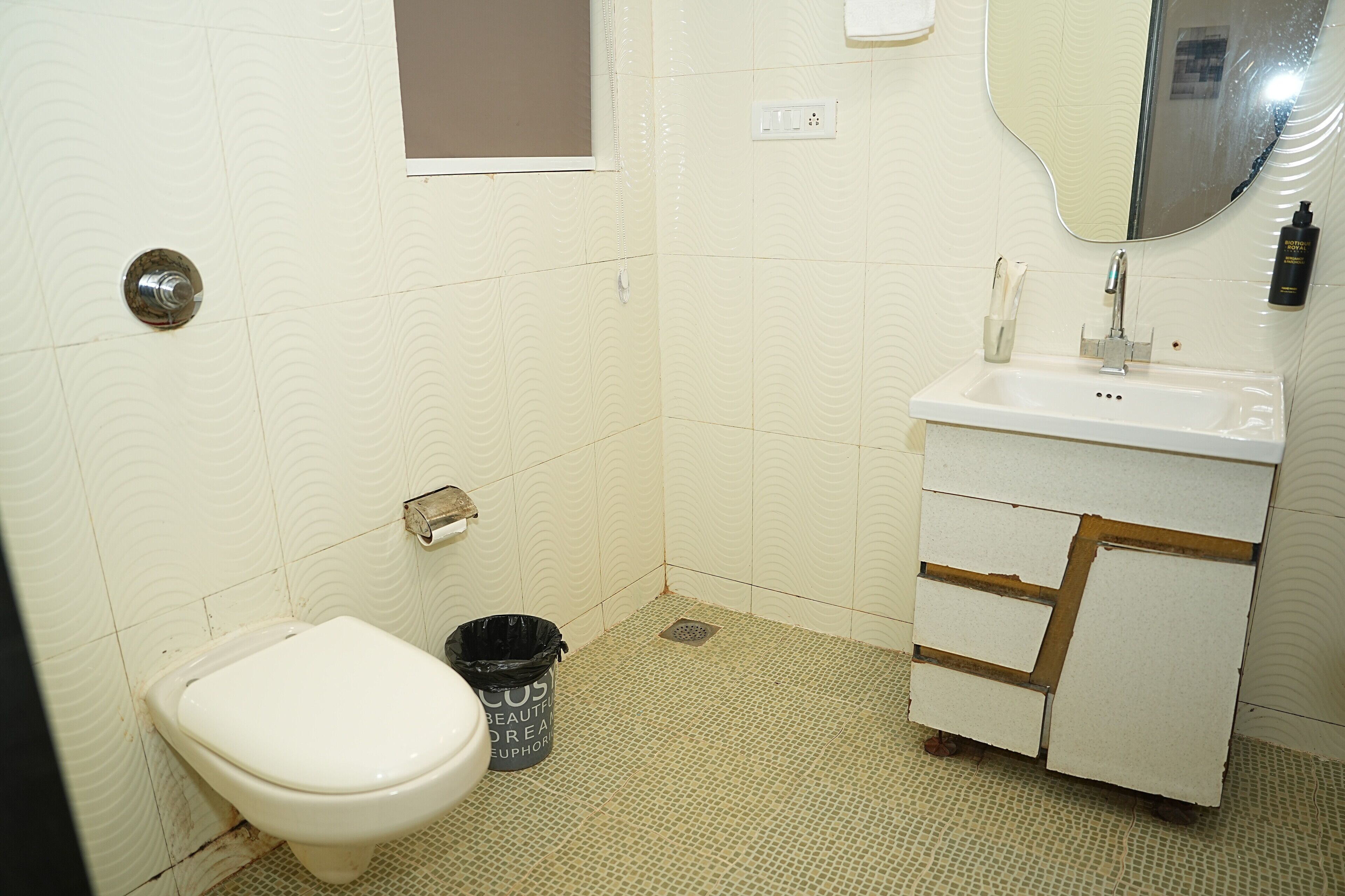 A small bathroom with a toilet, sink, and mirror.