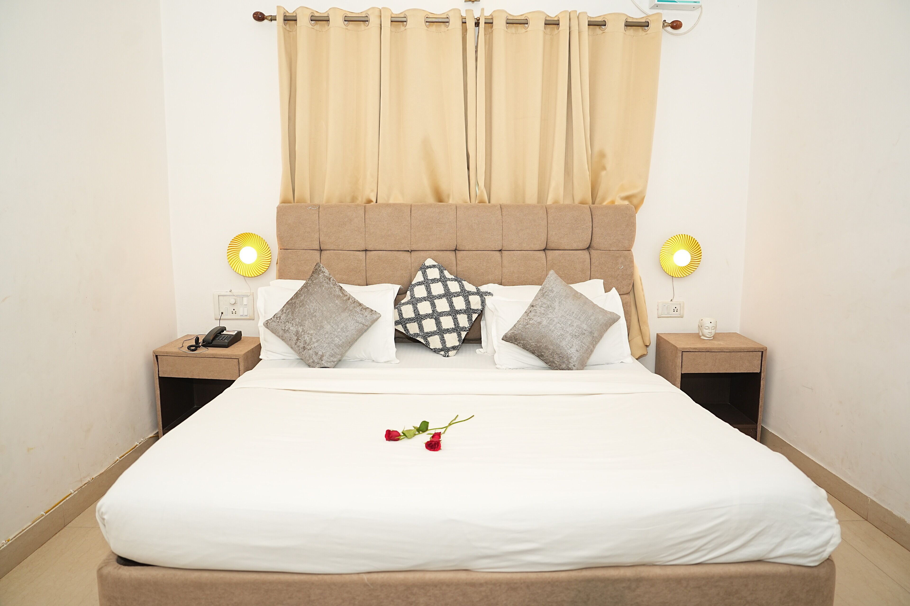 A neatly made bed with white bedding, two bedside tables with lamps, and a headboard.