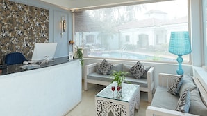 Una sala de estar moderna con un sofá blanco, una mesa de centro y un comedor con una mesa y sillas blancas.