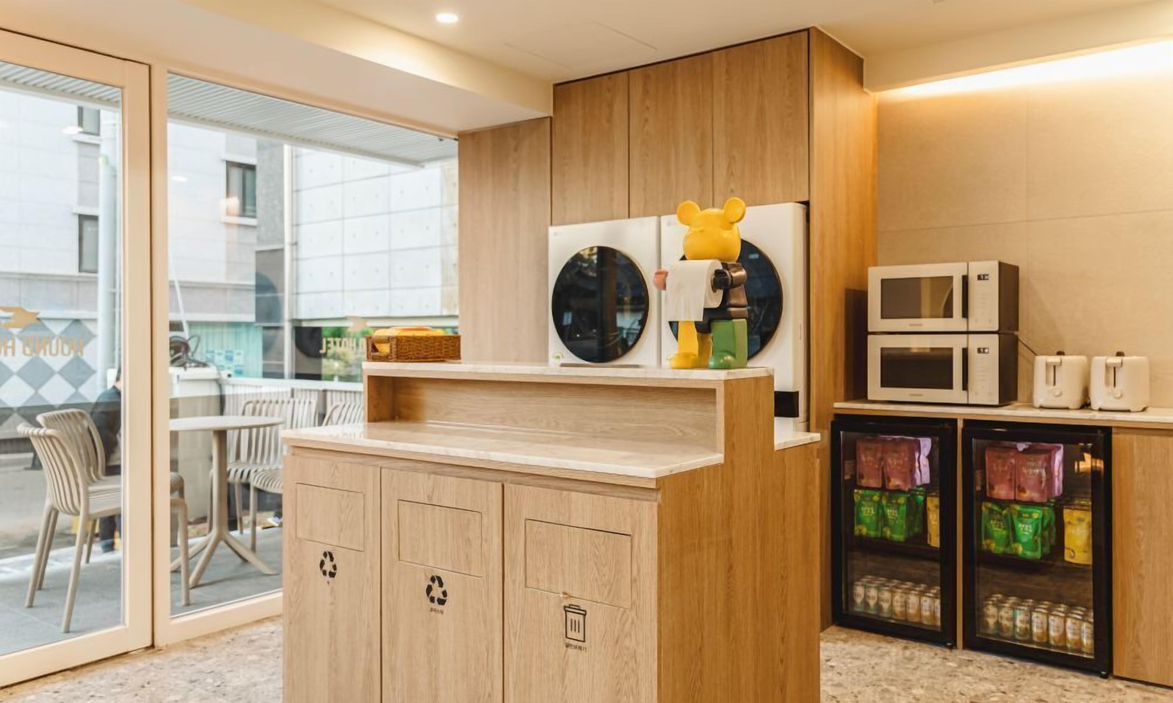 A modern kitchen with wooden cabinets, a microwave, and a refrigerator.
