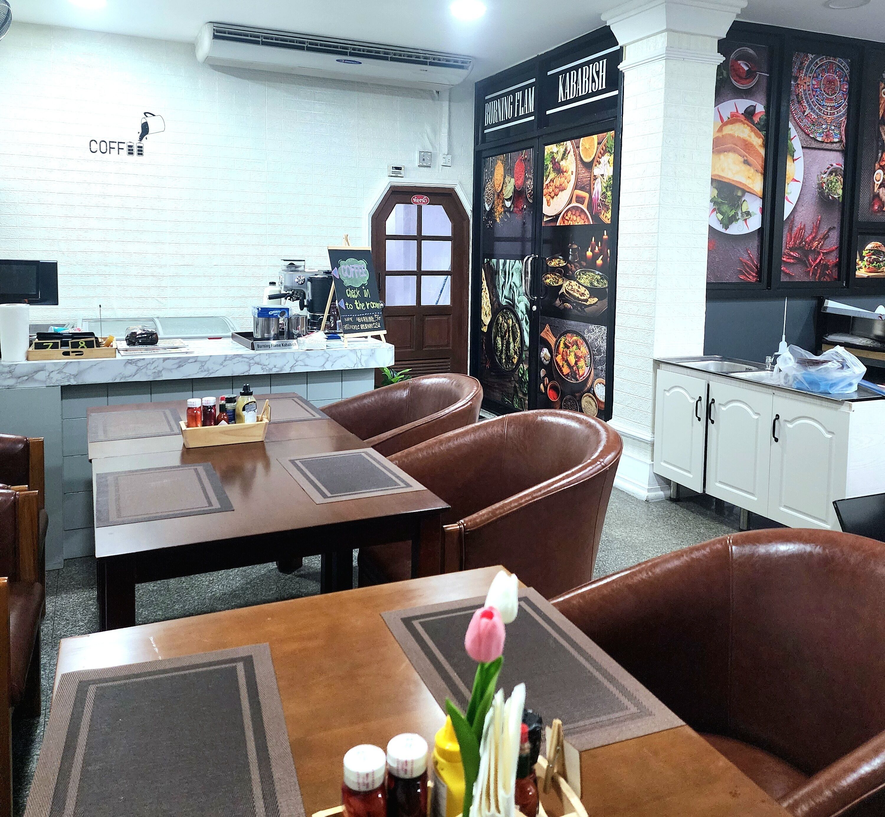 Un ristorante con angolo caffè, zona salotto e una porta decorata con immagini di cibo.