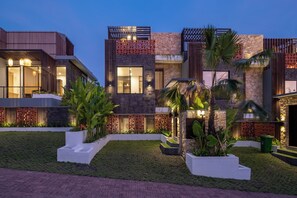 A modern multi-story building with a well-maintained garden and outdoor lighting. - Private Pool Vila 8B Close Melasti Beach (Ungasan)