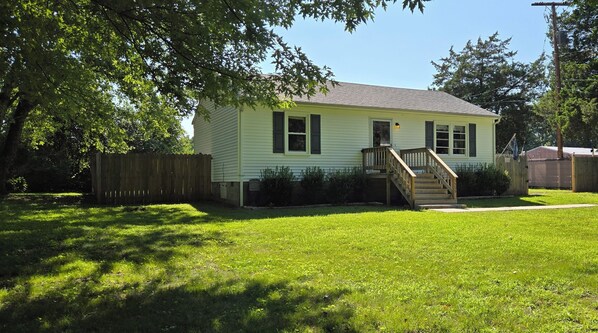 A single-story house with a front porch and a small staircase leading to the entrance.