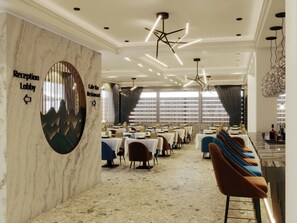 Een hotel lobby met een receptiebalie, een cafébar en een restaurantgedeelte met tafels en stoelen.