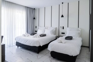 A modern hotel room with two beds, a large window with curtains, a marble floor, and a minimalist design. - Oros Paradise Hotel (Rhodes)