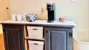 Eine Küchenzeile mit Kaffeemaschine, Spiegel und Stauschubladen.