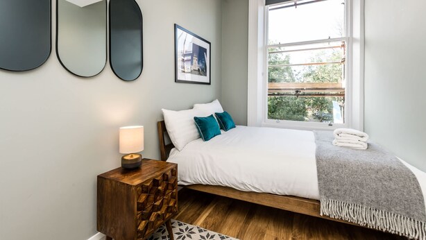 A bedroom with a bed, bedside table, lamp, and a window with a view. - Host Stay Catharine Quarters (Liverpool)