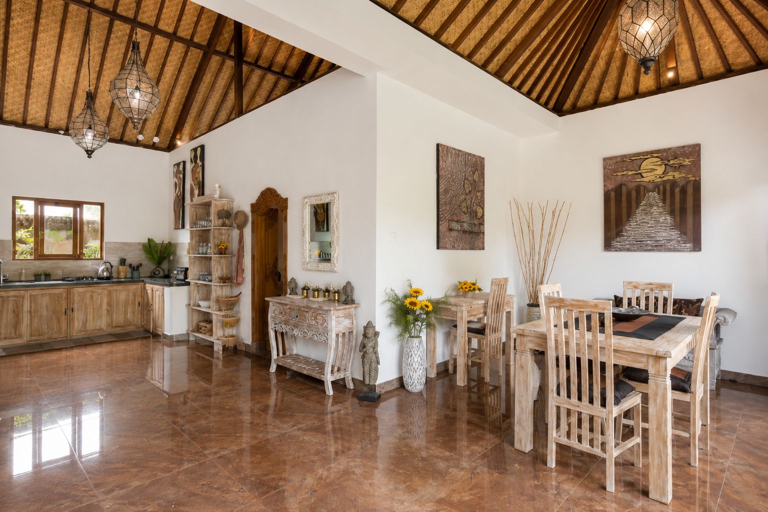Una cocina amplia con techo de madera, un comedor con mesa y sillas de madera, y un ventanal grande.