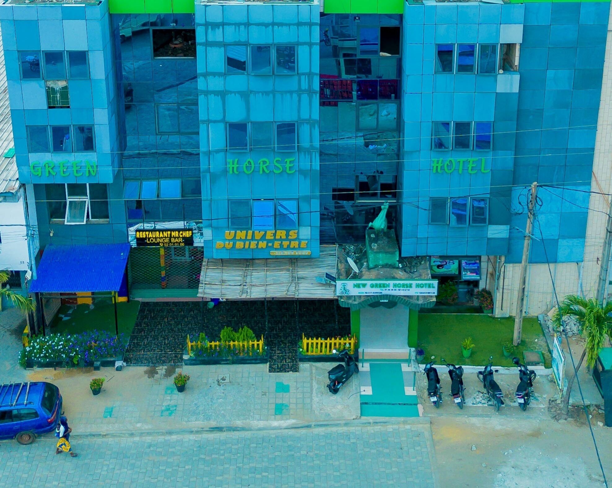 A multi-story building with signs for 'GREEN', 'HORSE', and 'HOTEL'.