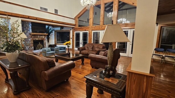 A spacious living room with leather sofas, a fireplace, and a chandelier. - Vacation, Wedding, Retreat & Family Gathering, Spa and Theater rooms - Sleeps 30 (Manchester)