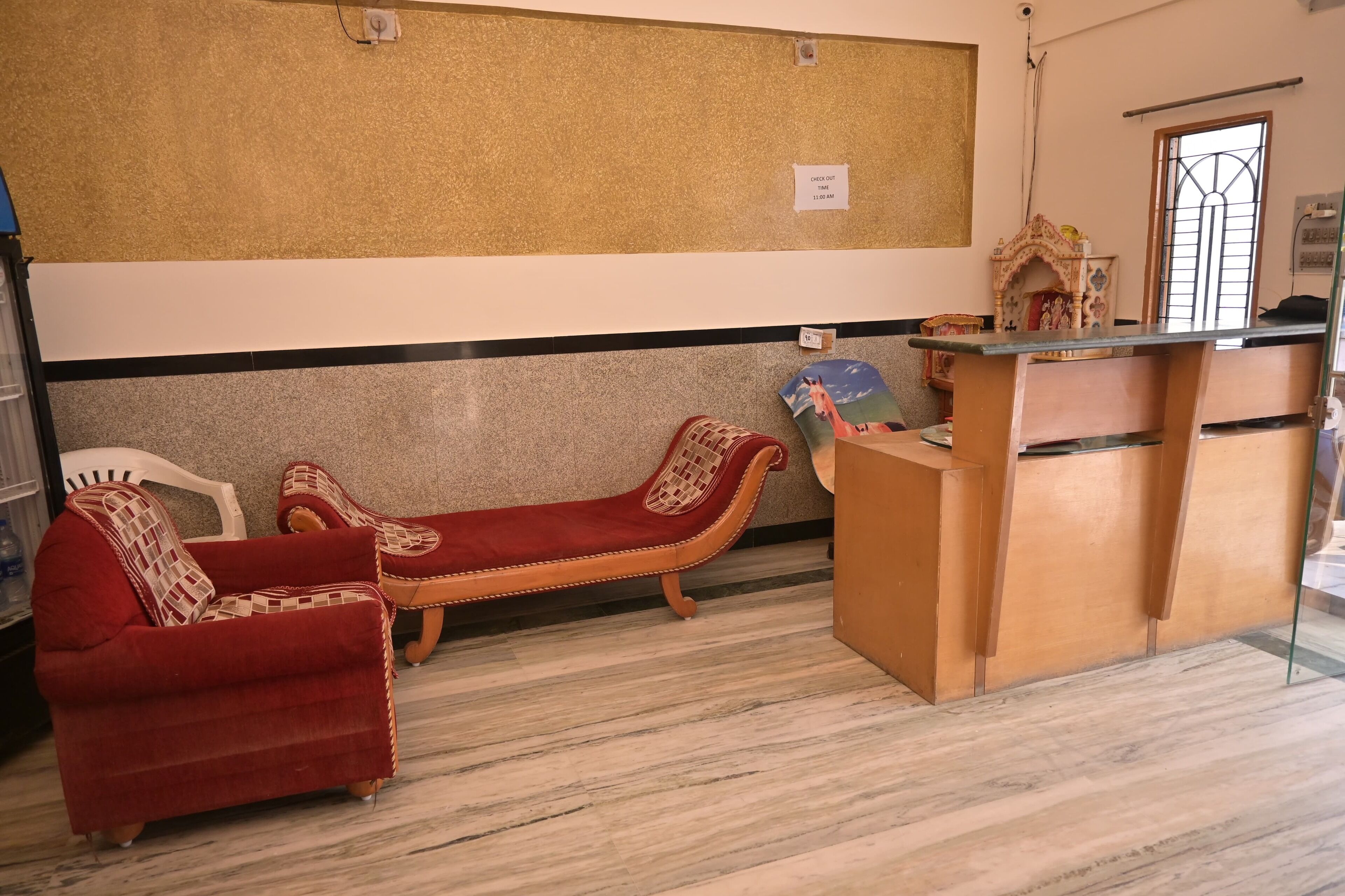 Un área de recepción con mostrador, sofá y sillón.