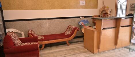 Un área de recepción con mostrador, sofá y sillón.