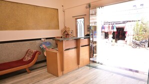 A reception area with a marble floor, a reception desk, a bench, and a view of the outside.