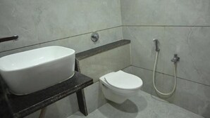 A bathroom with a white sink, toilet, and shower.