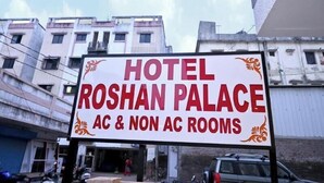 A sign for Hotel Roshan Palace advertising AC and non-AC rooms.