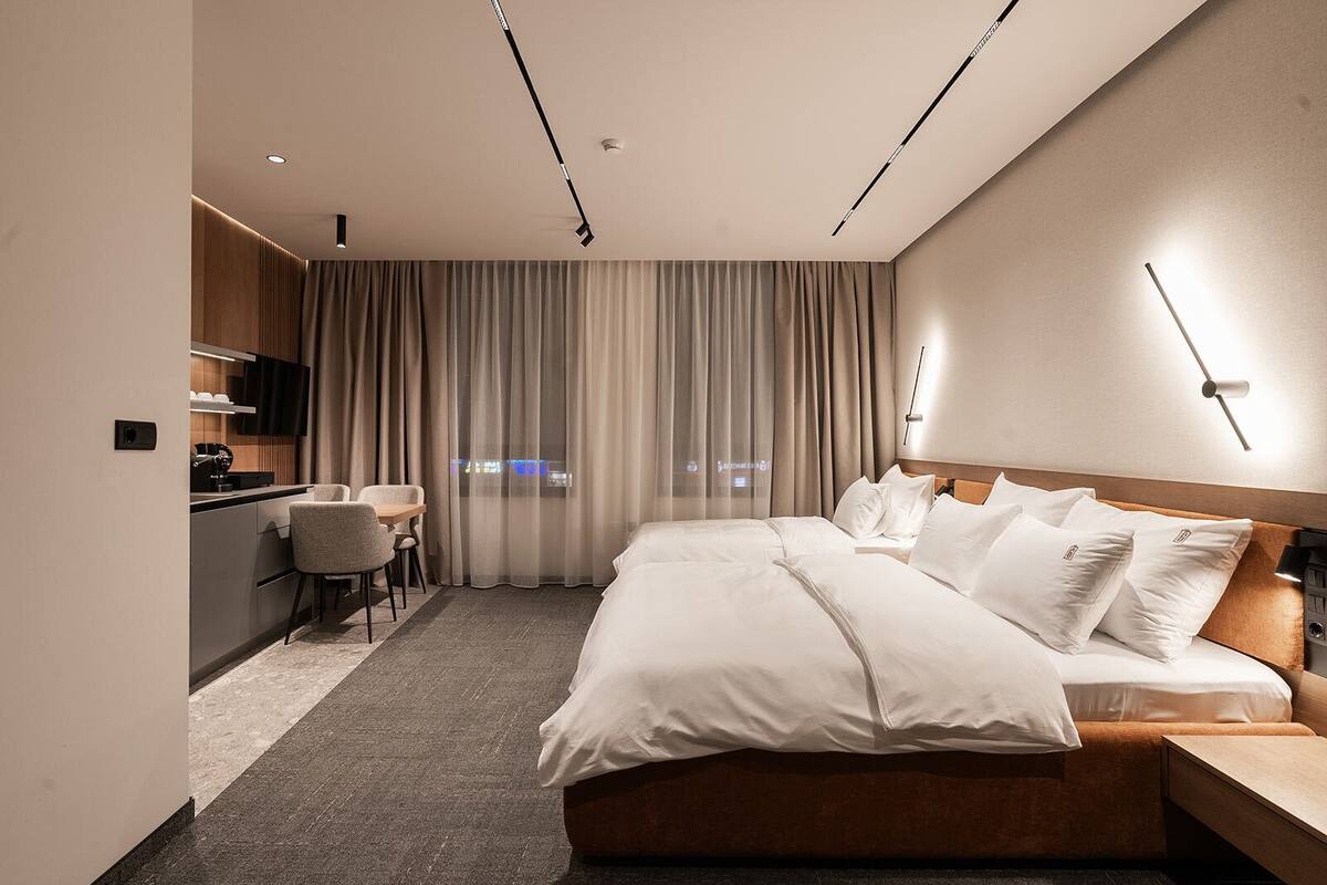 Une chambre d’hôtel moderne avec un grand lit, un bureau et une chaise.