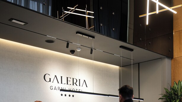 A hotel reception desk with a sign reading "GALERIA GARNI HOTEL". - Garni Hotel Galeria  (Banja Luka)