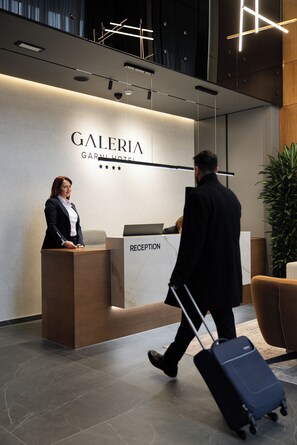 A hotel reception desk with a sign reading "GALERIA GARNI HOTEL". - Garni Hotel Galeria  (Banja Luka)