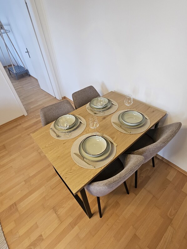 A dining table set with plates, glasses, and cutlery.