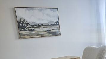 Ein Zimmer mit einem Holztisch, einem gemütlichen Sessel und einem Bild an der Wand.