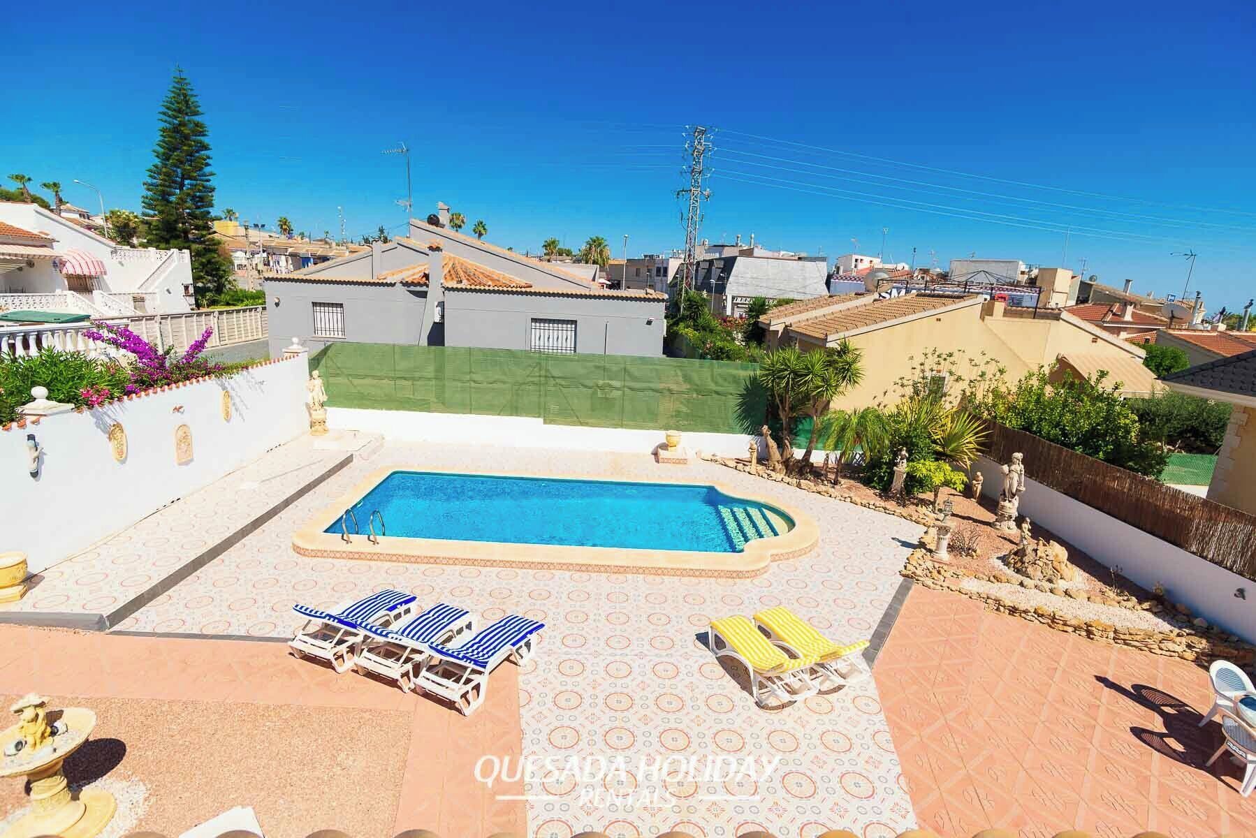 A rooftop pool with lounge chairs and a patterned patio area.
