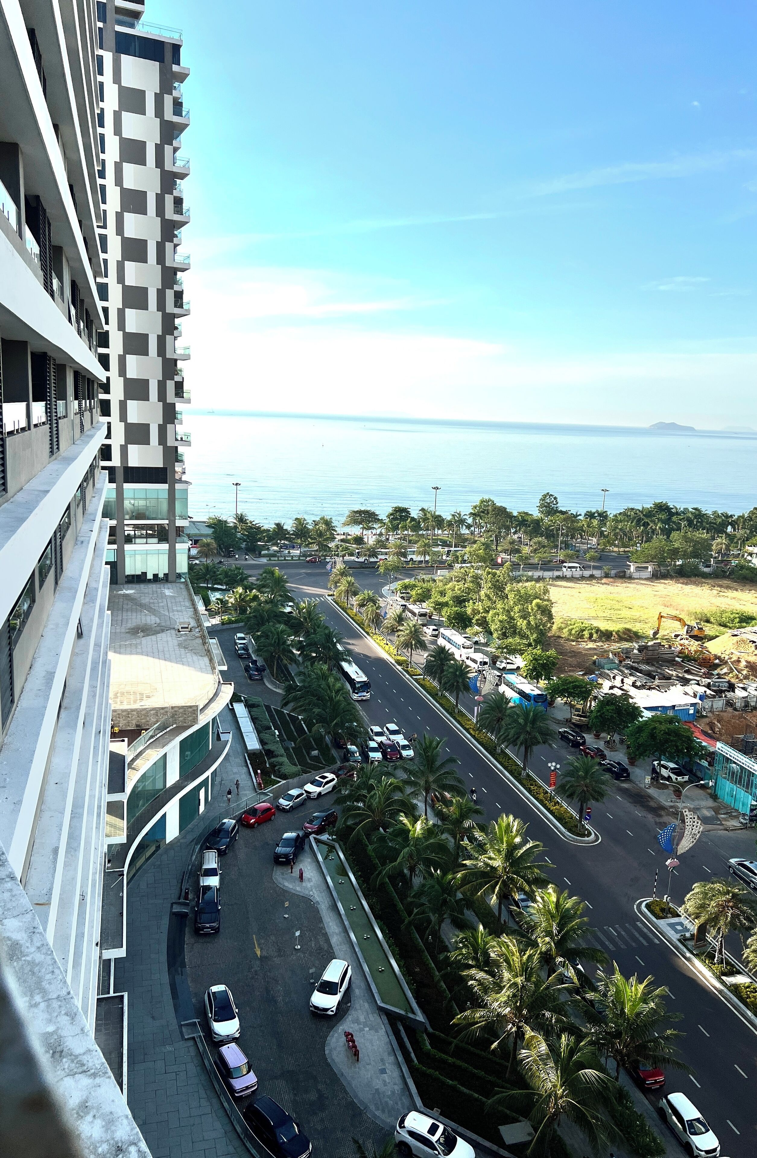 A high-rise building with a view of a coastal road and a construction site.