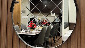 A round mirror with a diamond-patterned frame hanging on a wooden wall. - Stunning Ocean View Apartment in FLC Sea Tower (Quy Nhon Nam)