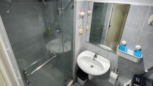 A modern bathroom with a glass-enclosed shower, a white sink, and a mirror above the sink. - MNM Place - Sea Residence - 0A (Pasay)