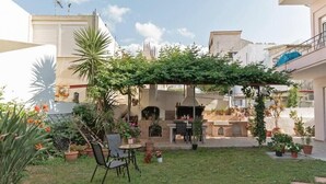 A courtyard with a pergola, outdoor seating, and a barbecue area. - Casa Valore by 8essentially (Chania)