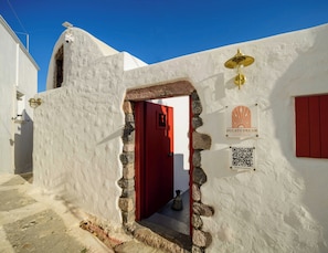 A white building with a red door, a sign for 'Ducato Dream Luxury Suite,' and a QR code.