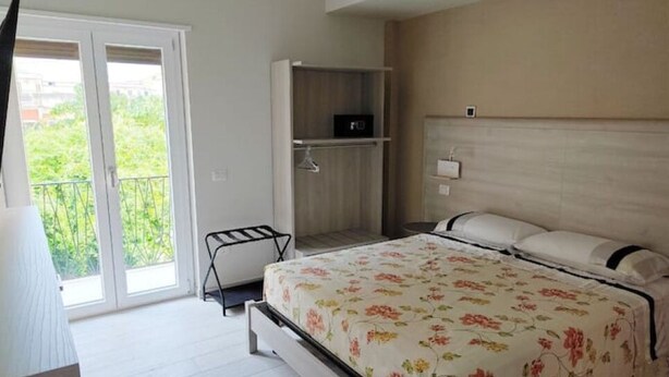 Une chambre à coucher avec un lit, une armoire et un balcon.