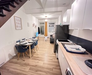 Eine moderne Küche mit Essbereich, Holzboden und einer Treppe.