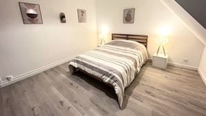 A bedroom with a bed, two bedside lamps, and three wall-mounted pictures. - Le Duplex 68m2 apartment close to shops, town center and beach (Calais)